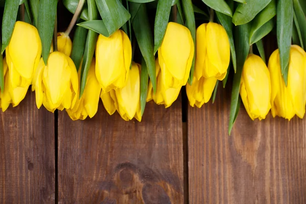 Beautiful yellow tulips on wooden background. Top view, copy space — Stock Photo, Image