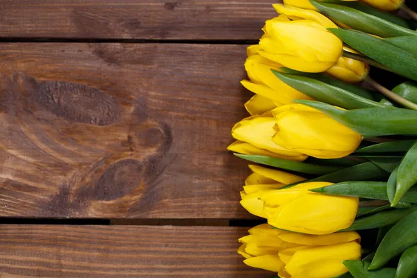 Beautiful yellow tulips on wooden background. Top view, copy space — Stock Photo, Image