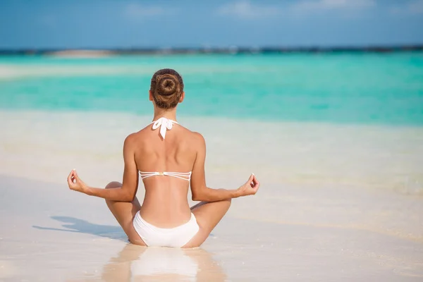 Portrait of young woman doing yoga exercises on tropical maldivian beach near ocean — Stock Photo, Image