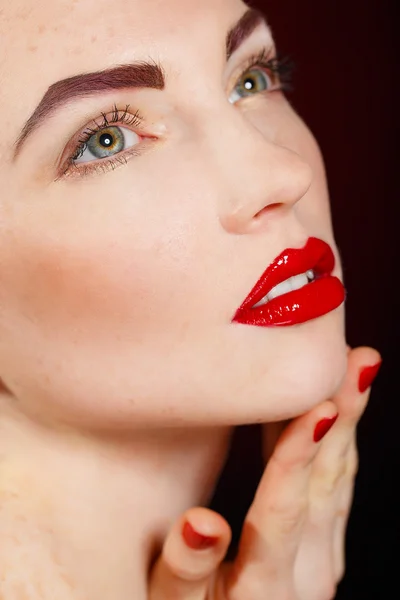 Retrato de cerca del sexy modelo de mujer joven europea con maquillaje glamuroso y manicura roja brillante. maquillaje de Navidad, labios rojos sangrientos con brillo —  Fotos de Stock