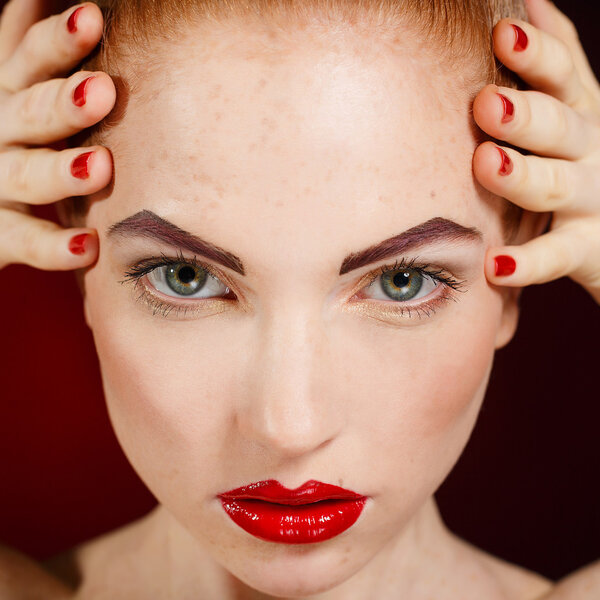 Close-up portrait of sexy european young woman model with glamour make-up and red bright manicure. christmas makeup, bloody red lips with gloss