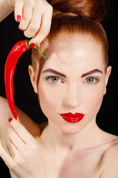 Portrait of beautiful red-haired woman with red hot spicy cayenne chili pepper — Stock Photo, Image