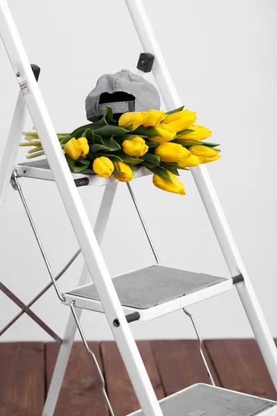 Beautiful bright yellow tulips More lying on sofa white stairs — Stock Photo, Image