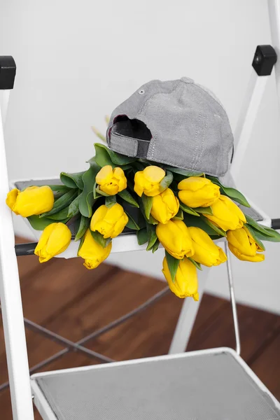 Beautiful bright yellow tulips More lying on sofa white stairs — Stock Photo, Image