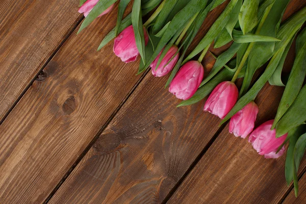 粉红郁金香盖在破旧的白色木桌上 — 图库照片