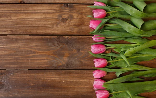 Tulipani rosa su tavolo di legno bianco squallido — Foto Stock