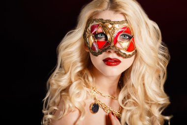 güzel genç sarışın bir kadın tiyatro maskesi yüzünde koyu arka plan üzerinde portresi