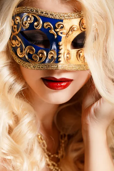 Retrato de una hermosa joven rubia con máscara teatral en la cara sobre un fondo oscuro —  Fotos de Stock