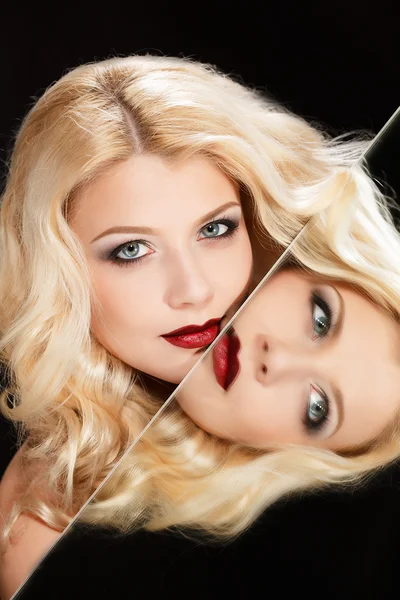 Portrait of an attractive blond woman with long curly hair, isolated on black studio shot — Stock Photo, Image