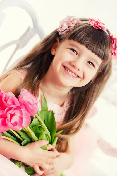 Adorable little girl with bouquet of tulips — Stock Photo, Image