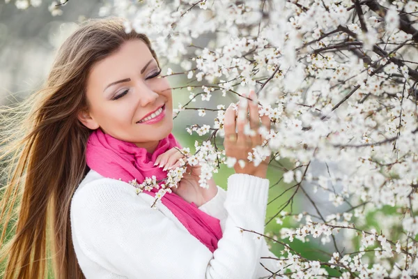 Portret van jonge brunette in de bloeiende lentetuin — Stockfoto