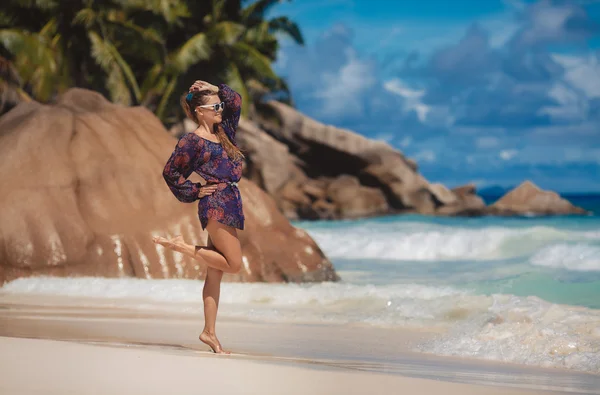 Kvinna på stranden i stora stenar — Stockfoto