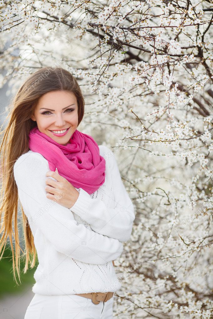 Portrait of young brunette in the spring blooming garden