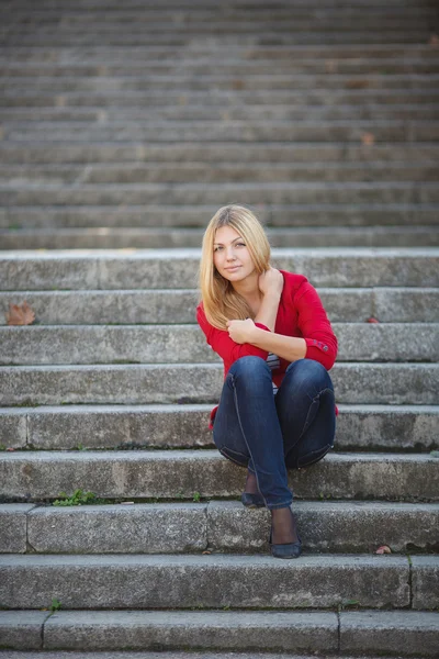 Dívka sedí na schodech úřední budovy — Stock fotografie