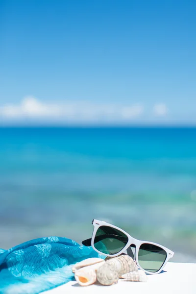 Summer concept with sunglasses and seashell on sand — Stock Photo, Image