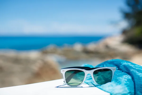 Concetto estivo con occhiali da sole e conchiglia sulla sabbia — Foto Stock
