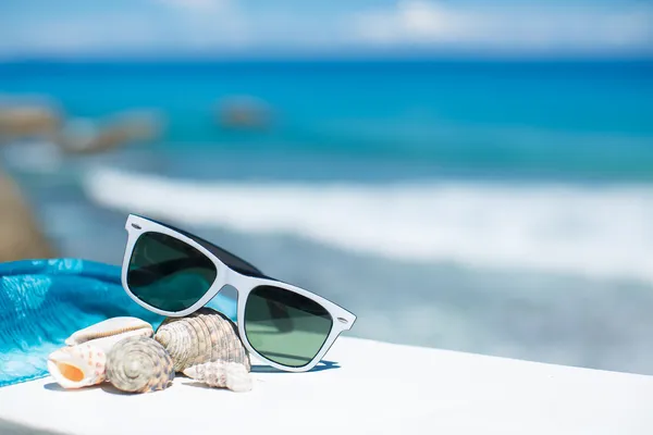 Summer concept with sunglasses and seashell on sand — Stock Photo, Image