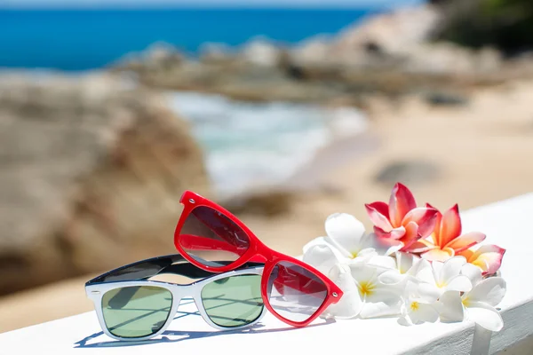 Two pairs of sunglasses on background of ocean — Stock Photo, Image