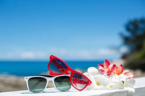 Two pairs of sunglasses on background of ocean — Stock Photo, Image