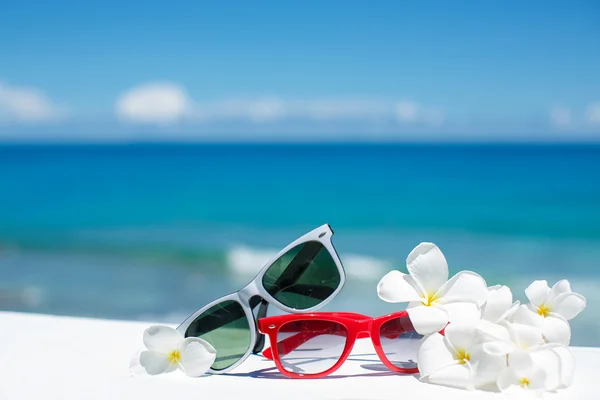 Dwie pary okularów przeciwsłonecznych na tle ocean — Zdjęcie stockowe