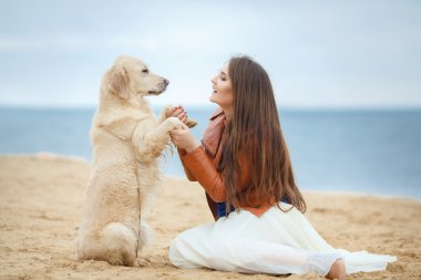 Kumsalda köpeği olan kız.