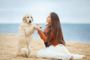 Kumsalda köpeği olan kız.