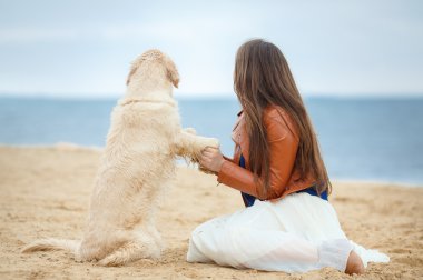 Kumsalda köpeği olan kız.