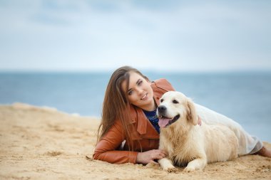 Kumsalda köpeği olan kız.