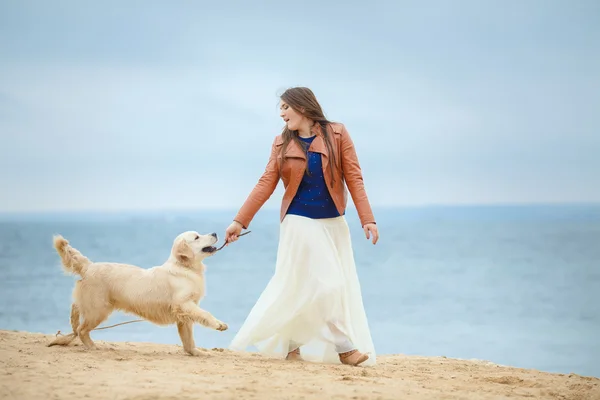 Flicka med hund på stranden — Stockfoto