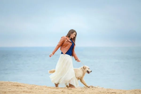 Menina com cão na praia — Fotografia de Stock