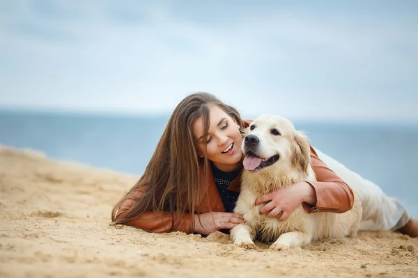 Flicka med hund på stranden — Stockfoto