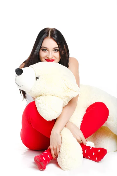 Beautiful young brunette woman holding a teddy bear — Stock Photo, Image