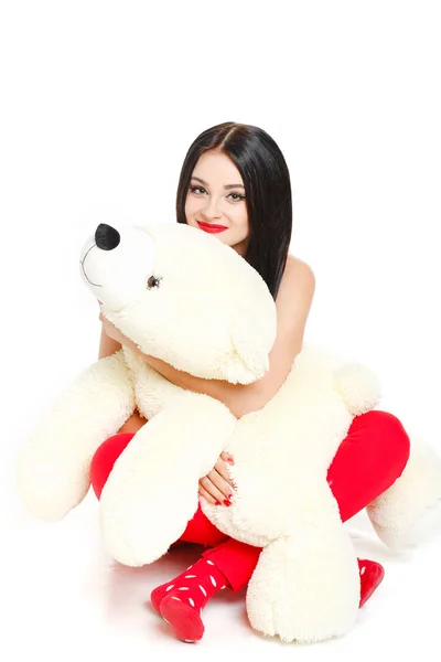 Beautiful young brunette woman holding a teddy bear — Stock Photo, Image