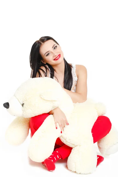 Beautiful young brunette woman holding a teddy bear — Stock Photo, Image