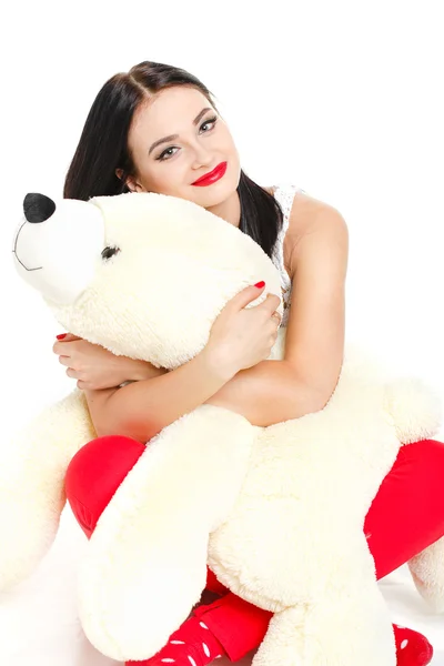 Beautiful young brunette woman holding a teddy bear — Stock Photo, Image