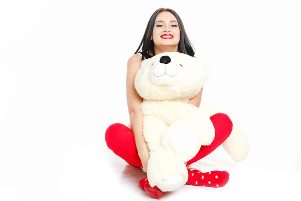 Beautiful young brunette woman holding a teddy bear — Stock Photo, Image