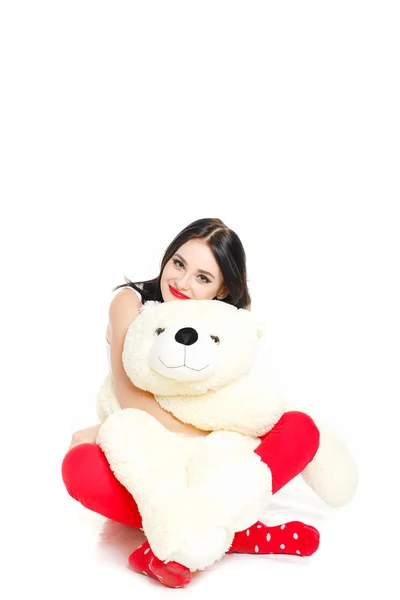 Beautiful young brunette woman holding a teddy bear — Stock Photo, Image