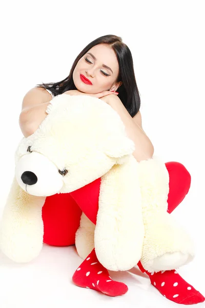 Beautiful young brunette woman holding a teddy bear — Stock Photo, Image