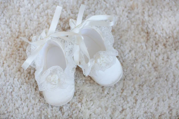 Baby booties on white lace. — Stock Photo, Image