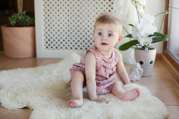Porträtt av en liten flicka som sitter på golvet — Stockfoto