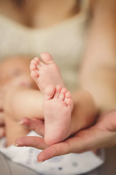 Baby benen. benen pasgeboren in ouders hand. baby voeten. — Stockfoto