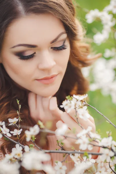 Porträtt av ung brunett i våren blommande trädgården — Stockfoto