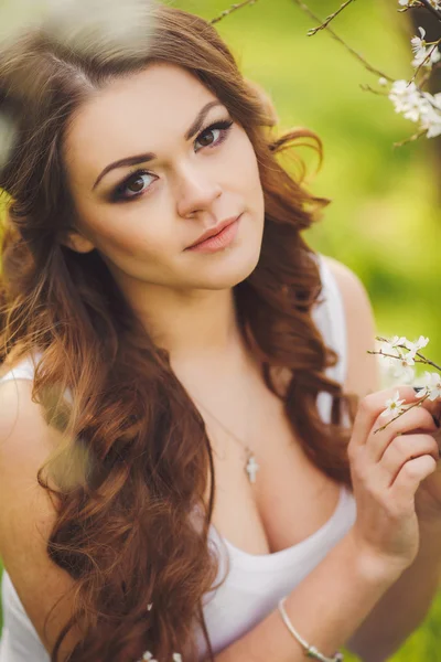 Retrato de la joven morena en el jardín floreciente de primavera —  Fotos de Stock