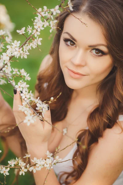 Retrato de jovem morena no jardim florescendo primavera — Fotografia de Stock