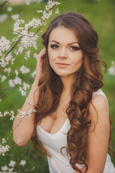 Portret młoda brunetka w ogrodzie kwitnące wiosną — Zdjęcie stockowe
