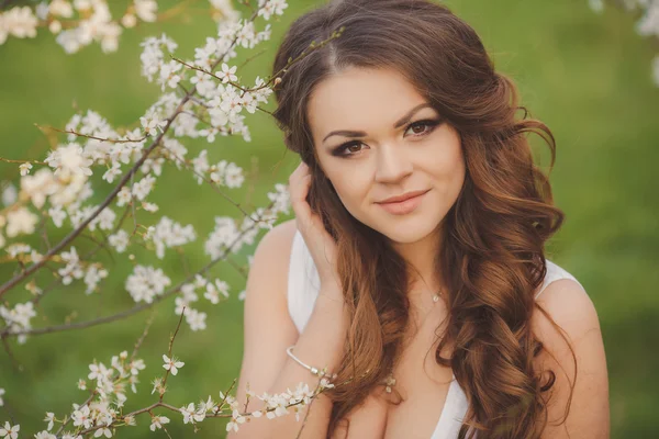 Retrato de la joven morena en el jardín floreciente de primavera —  Fotos de Stock