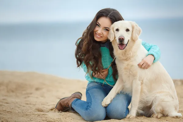 Retrato de bela jovem mulher brincando com o cão na costa do mar — Fotografia de Stock