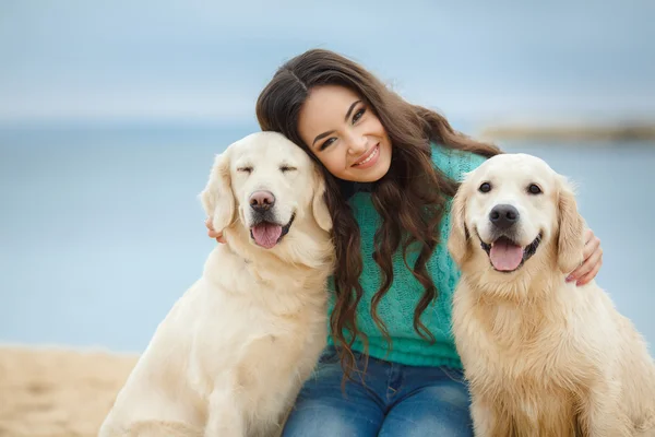 Porträtt av vacker ung kvinna leker med hunden vid havet — Stockfoto