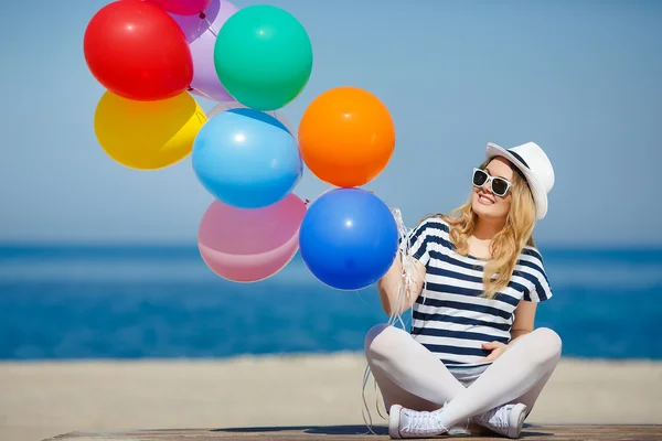 Pregnant woman in sunglasses and a white hat with balloons — Stock Photo, Image