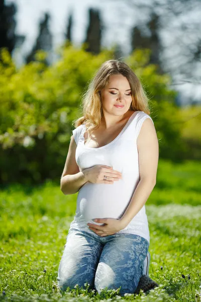 Portrait Femme enceinte en bonne santé assise sur l'herbe verte — Photo